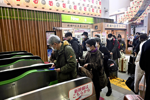 運転が再開される秋田新幹線に乗り込むため、改札を通る利用客たち（３０日午前１０時１８分、秋田駅で）