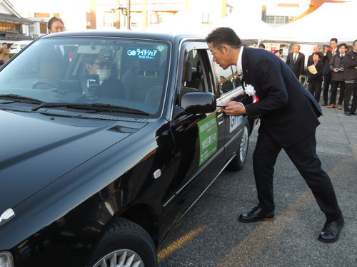 【デモ運行としてアプリで呼んだライドシェア車両に乗り込む鈴木市長＝伊勢市で】