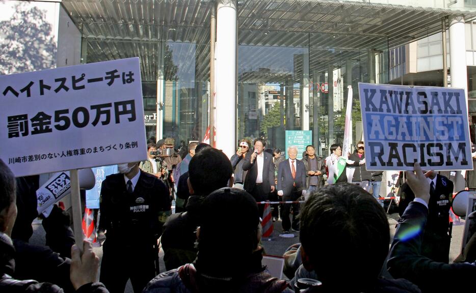 さいたま地裁からデモ禁止の仮処分を出された男性らが行う街頭演説に抗議する市民ら＝15日午後、川崎市