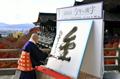 今年の漢字「金」を揮毫する森清範貫主（１２日午後、京都市東山区の清水寺で）＝川崎公太撮影