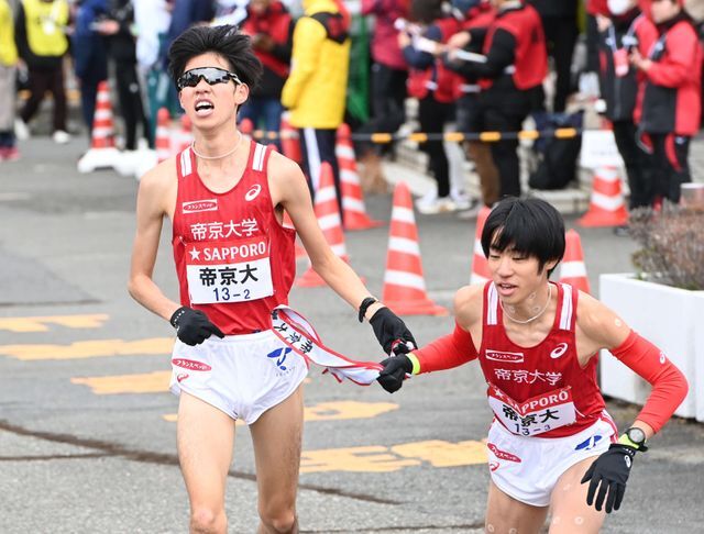 帝京大2区山中博生選手（左）は3区柴戸遼太選手にタスキを渡す(写真：日刊スポーツ/アフロ)