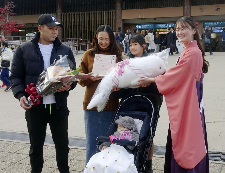 セレモニーで記念品を受け取る樽谷純也さん（左端）と家族＝15日午後、広島県廿日市市の宮島