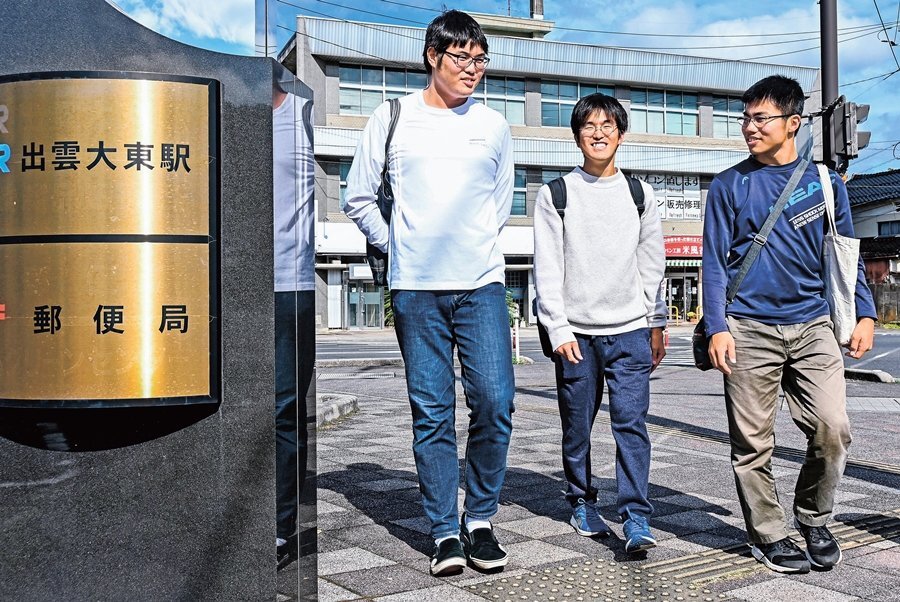 木次線沿線を散策する中村駿大さん（中央）＝雲南市大東町飯田、出雲大東駅