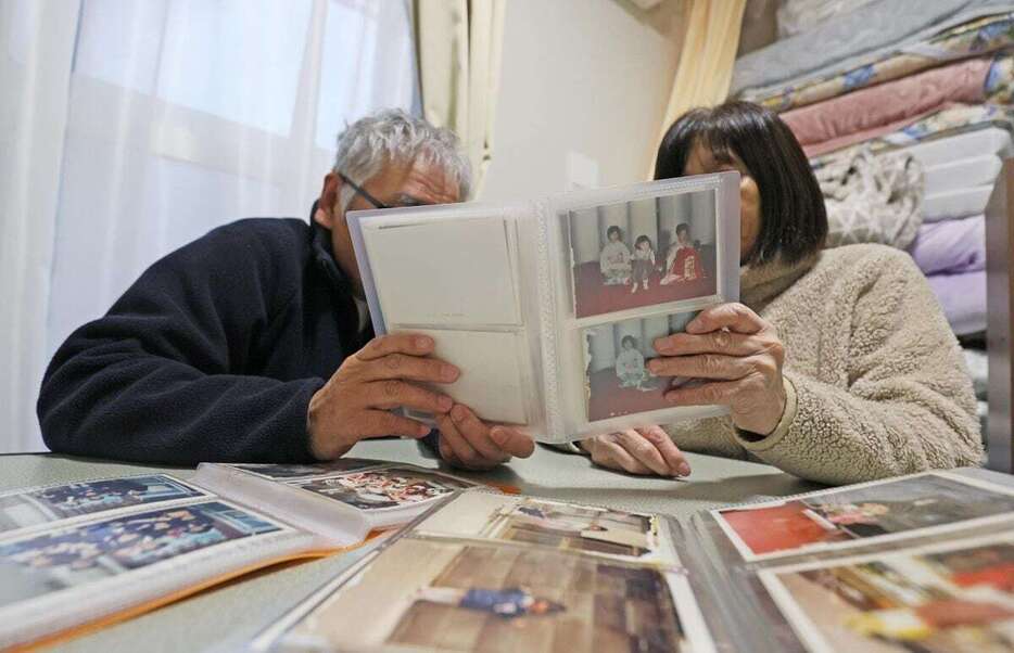 「今は大切な家」と語る仮設住宅で、アルバムを見つめる夫婦＝12月27日、石川県輪島市（泰道光司撮影）