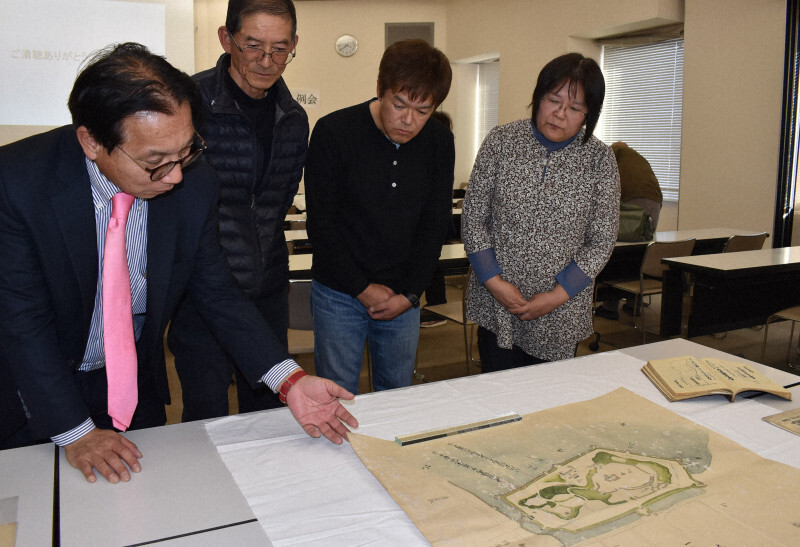 公開された鳥羽城の絵図をのぞき込む（左から）盆野行輝さん、木下房美さん、大山寿文さん、渡辺恵さん＝三重県鳥羽市内で2024年12月14日、下村恵美撮影