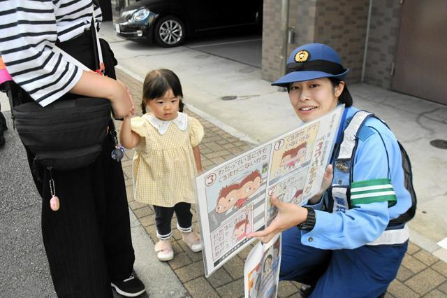 重大な交通事故が多い交差点で、横断歩道の安全な渡り方を市民に説明する警察官=2024年9月24日午後2時36分、東京都墨田区東向島2丁目、吉村駿撮影