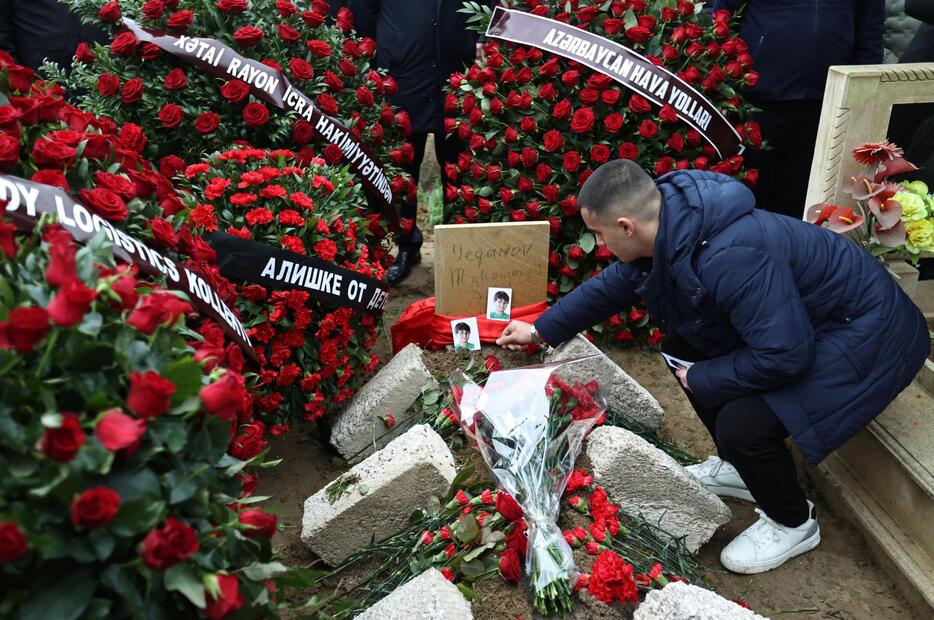 28日、アゼルバイジャン・バクーの墓地で旅客機墜落事故の犠牲者を追悼する人（ロイター＝共同）