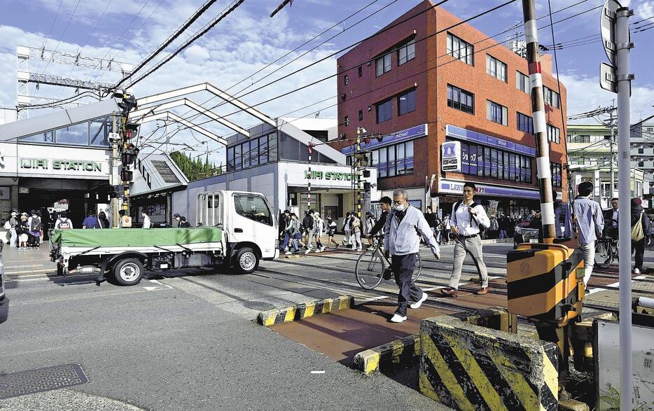 朝、通勤通学などの歩行者や車で混雑する井尻駅前の踏切