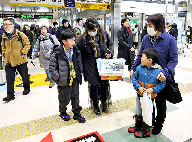 帰省ラッシュを迎え、ＪＲ山形駅で再開を喜ぶ家族＝28日午前10分50分、山形市