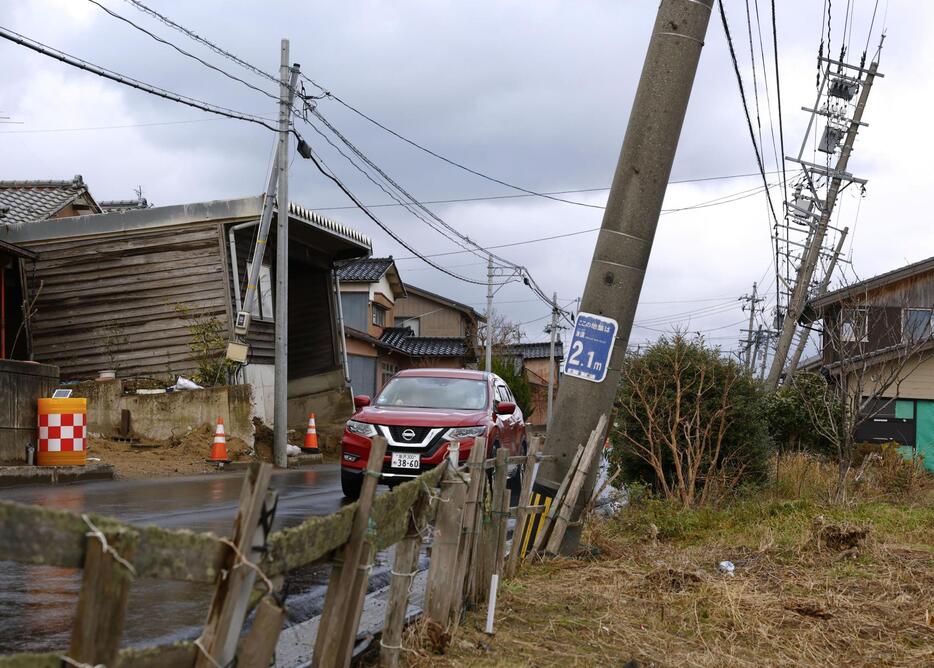 電柱が傾くなどの能登半島地震による液状化被害が残る石川県内灘町西荒屋地区＝22日午後