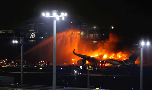 羽田空港ので黒煙を上げて炎上する旅客機（１月２日、羽田空港で）