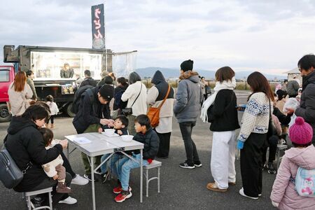 キッチンカーに並ぶ来場者。お祭り気分で朝食を味わった＝佐賀市の防災ステーション