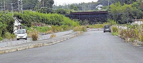 北環状線の未開通部分。片側２車線の道路がほぼできているが、正面の土地に埋まった産廃を処理できず、工事はストップしている（１１月、千葉県白井市で）