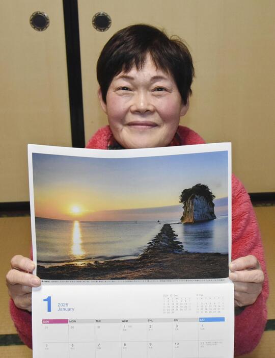 完成した「奥能登絶景海道カレンダー」2025年版を手にする高畠和子さん＝12日、石川県珠洲市