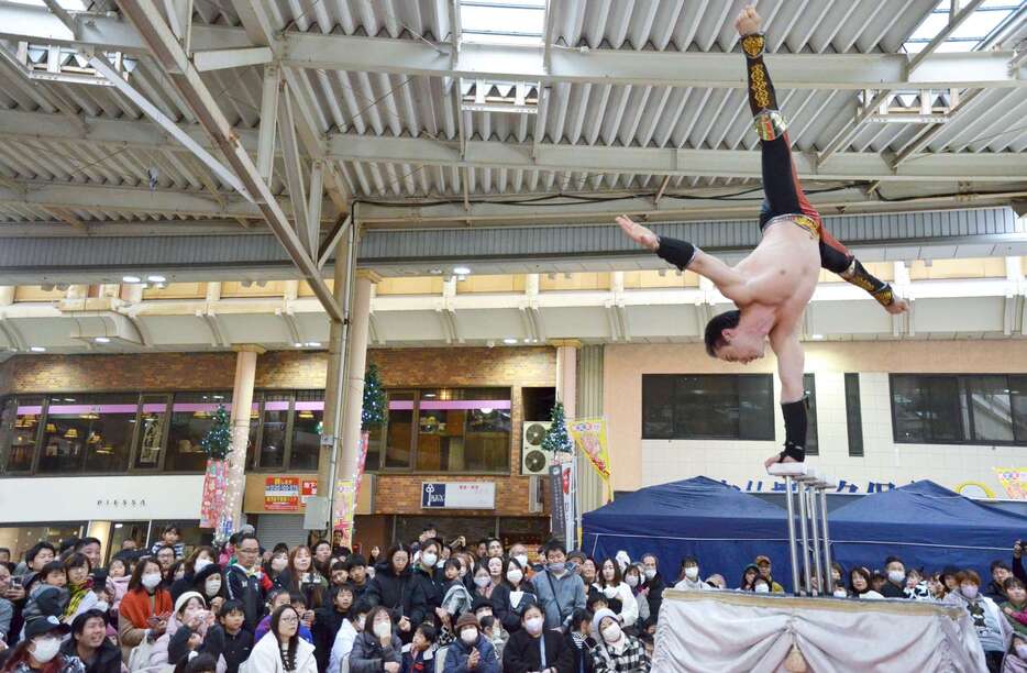 ハンドバランスを披露する木下大サーカスの団員＝１５日、鹿児島市の天文館ベルク広場