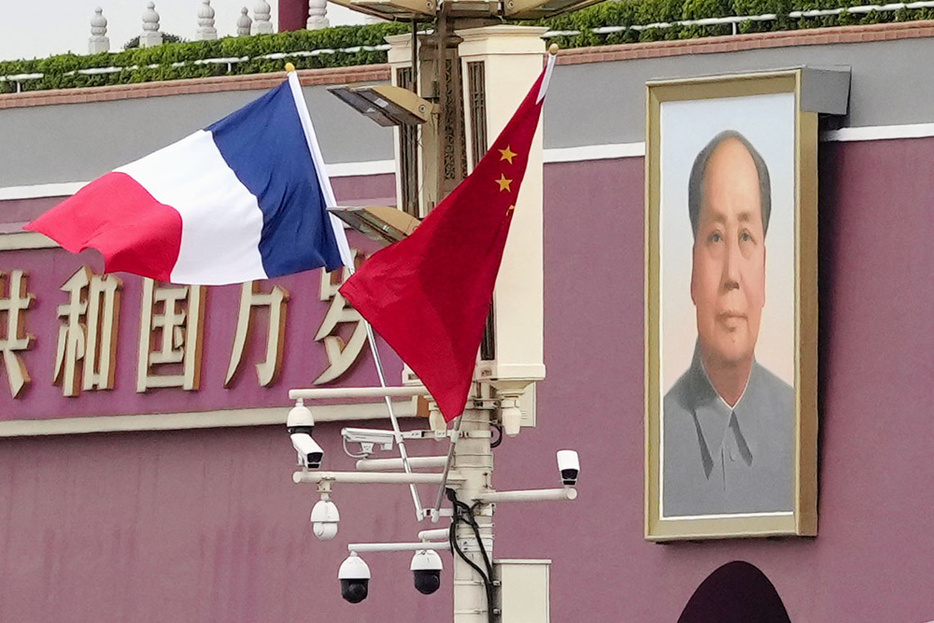 昨年4月、北京の天安門前に掲げられたフランス（左）と中国の国旗（共同）