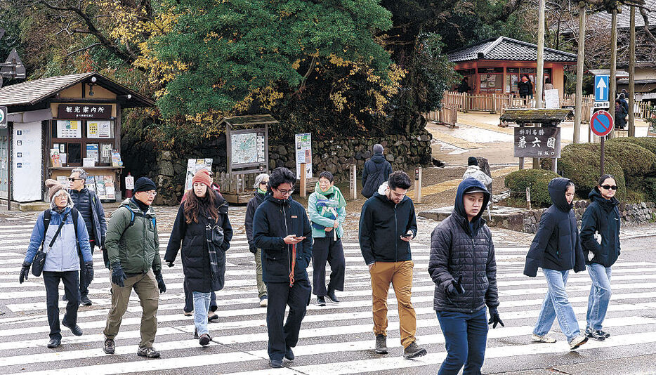 兼六園の前を歩く外国人観光客。早朝にはイノシシの目撃情報があった＝１２日午前１１時３５分、金沢市兼六町