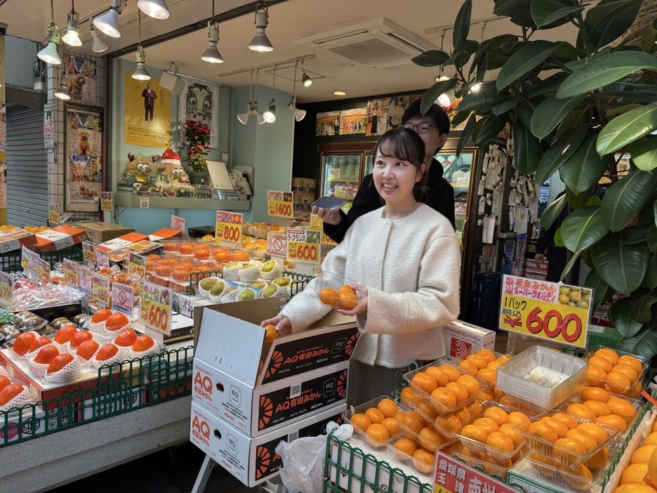 みかんを陳列する熊谷実帆アナウンサー