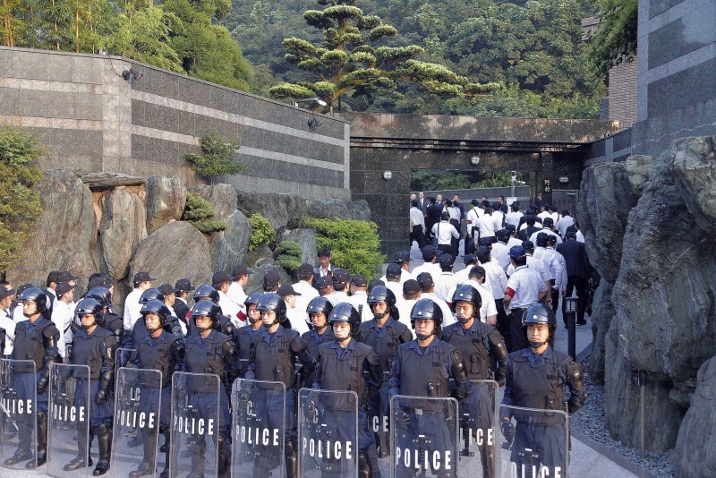 頂上作戦に着手し、厳重警戒の中、工藤会の野村悟総裁宅に入る福岡県警の捜査員＝北九州市小倉北区で2014年9月11日午前6時44分