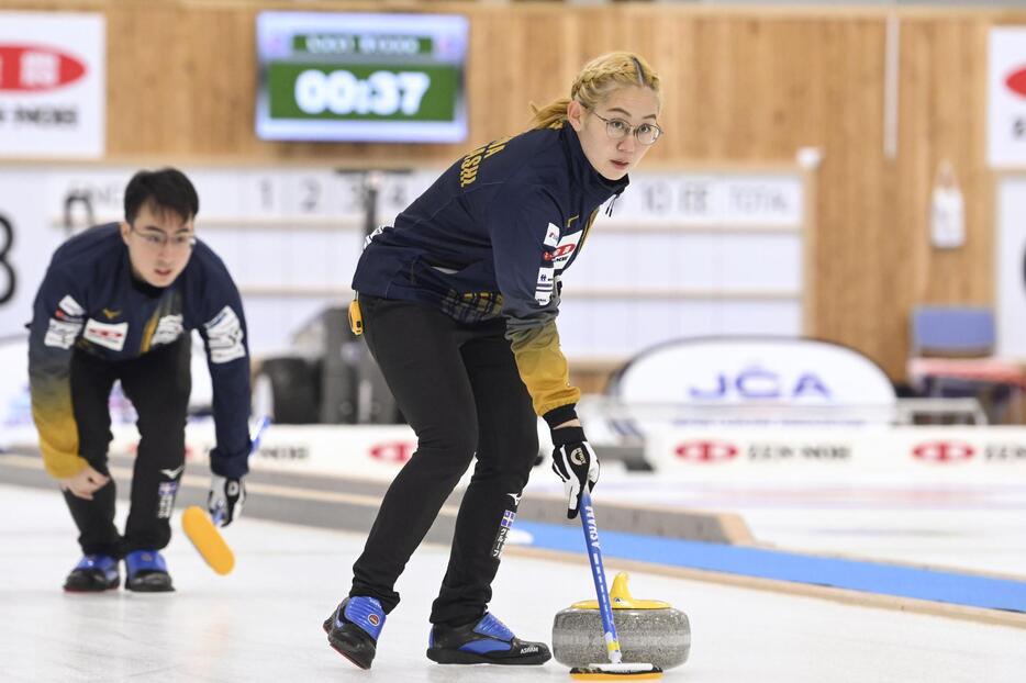 カーリングの日本混合ダブルス選手権2次リーグ初戦でプレーする小穴桃里（手前）と青木豪＝稚内市みどりスポーツパーク（（C）JCA/H.IDE）