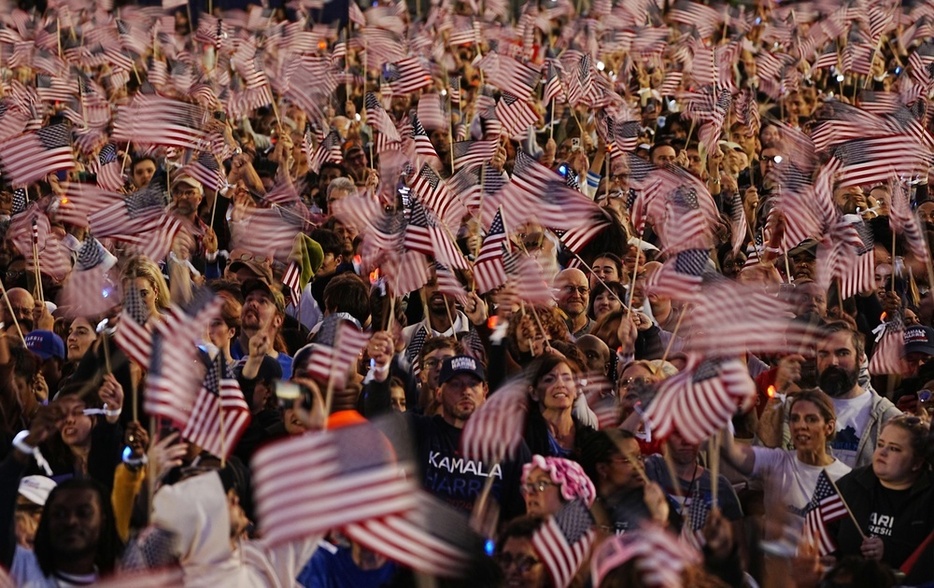 10月、ワシントンで開かれた米大統領選の集会で星条旗を振る参加者（共同）