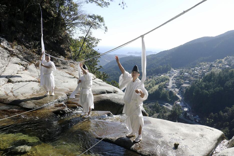 「那智の滝」の上に架かるしめ縄を張り替える熊野那智大社の神職＝27日午前、和歌山県那智勝浦町