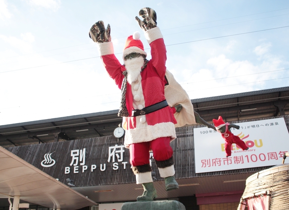 クリスマスに合わせ、サンタの衣装に衣替えした油屋熊八のブロンズ像＝別府市のJR別府駅東口