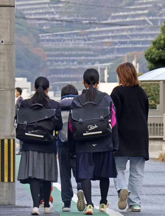 被害生徒の学校に登校する生徒ら＝17日午前、北九州市小倉南区