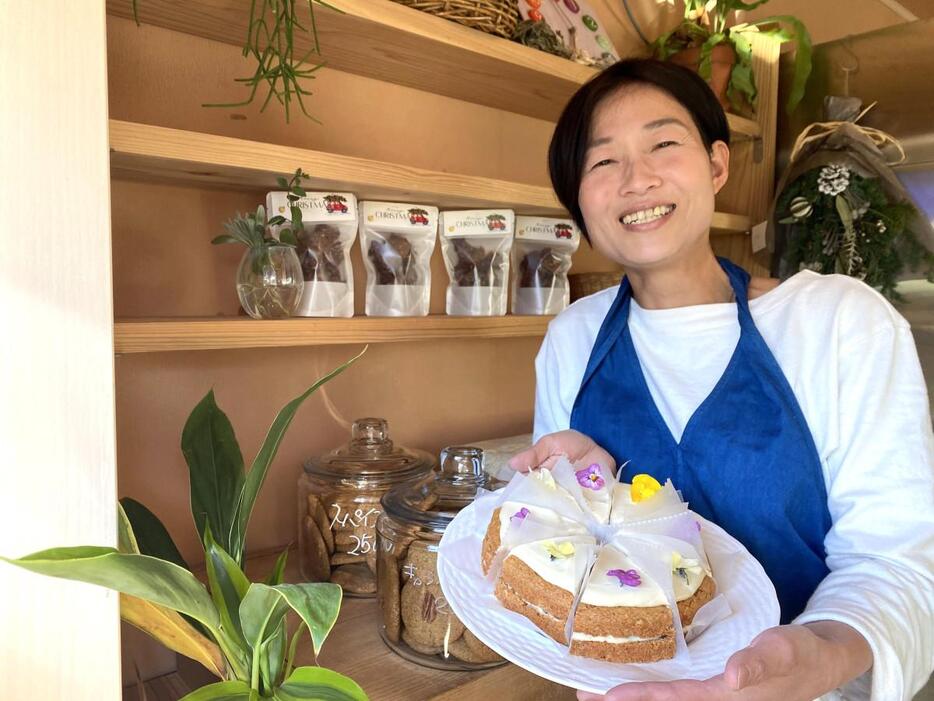 店主の関慎子さん。手には一番人気という「キャロットケーキ」