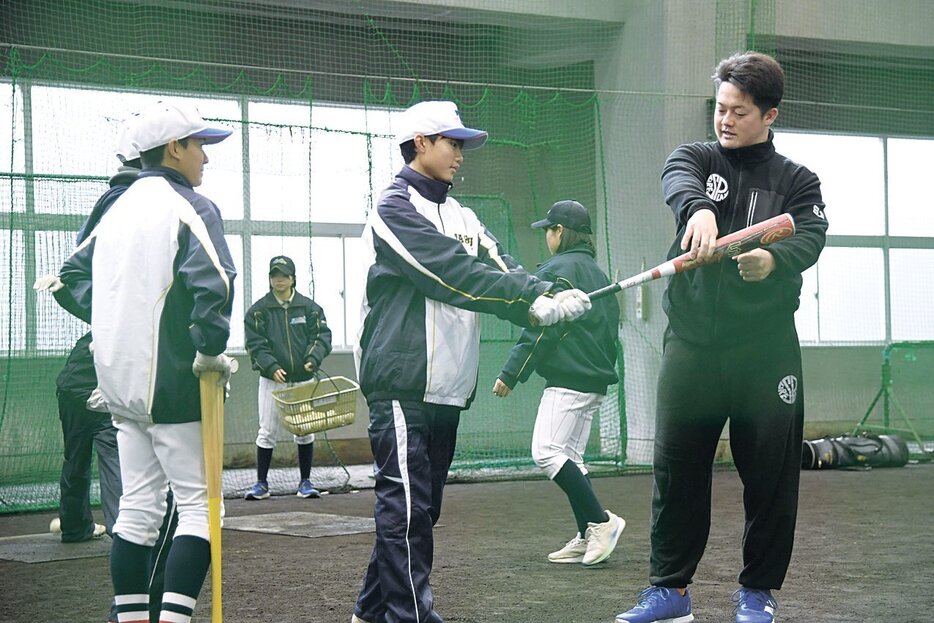 中学生に打撃のこつをアドバイスする牧選手（右）