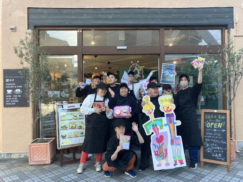 店の前でポーズをとる「嬉々！！CREATIVE GALLERY ＆ CAFE」のメンバーら