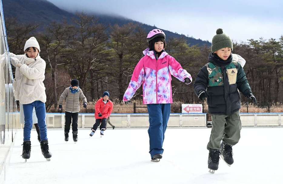 スケートを楽しむ子どもたち＝２１日、えびの市のえびの高原屋外アイススケート場