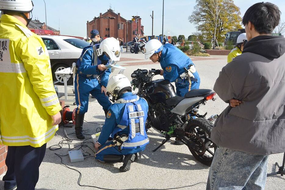 取り締まりでバイクの排気音を測定する警察官＝２０日、横浜市中区新港１丁目