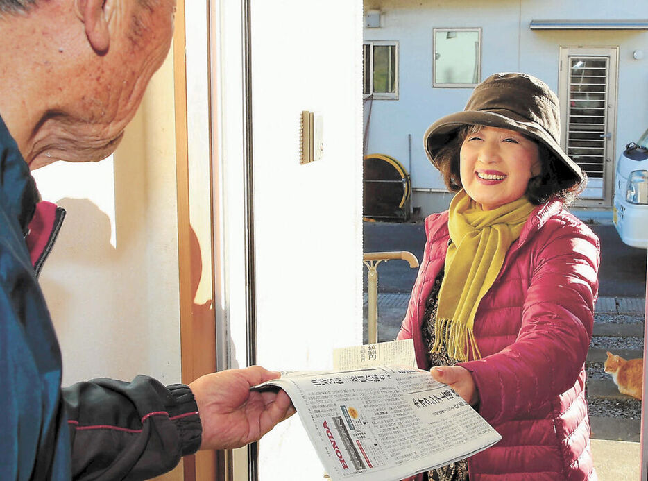 開通式前に朝刊を配達する木村さん（右）＝１９日午前８時１０分ごろ、宮城県女川町出島