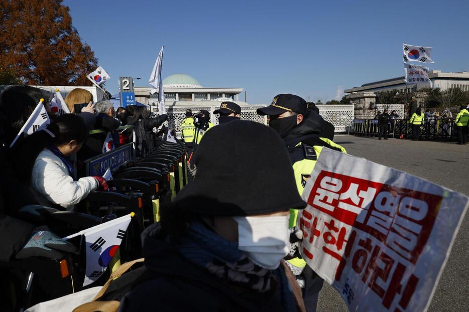 国会前で韓国の尹錫悦大統領の弾劾などを求める人たち＝7日、ソウル（共同）