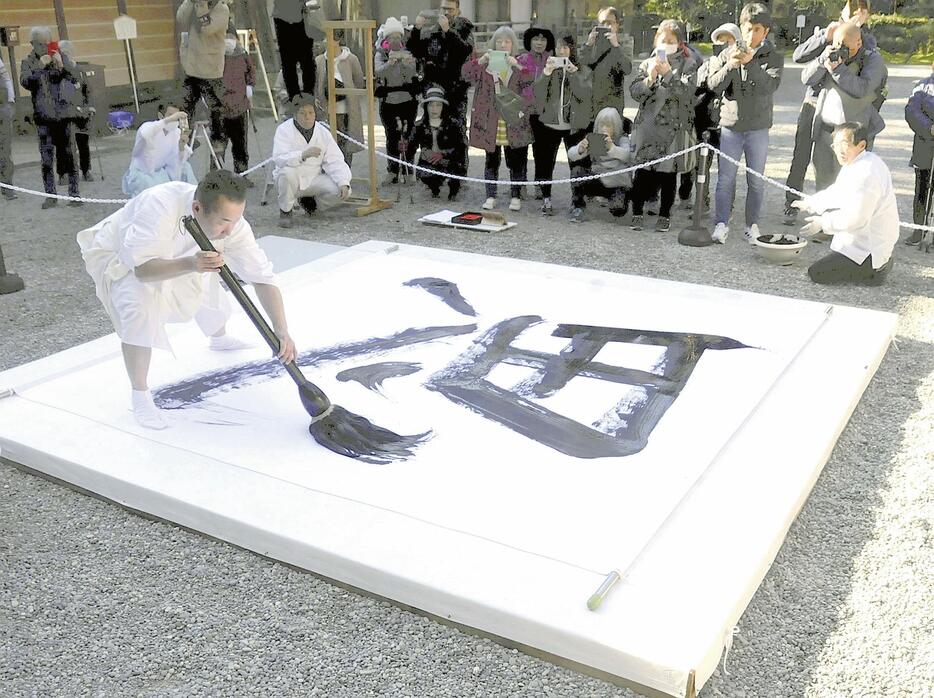 「思」の字を一気に書き上げる九鬼宮司（和歌山県田辺市本宮町で）