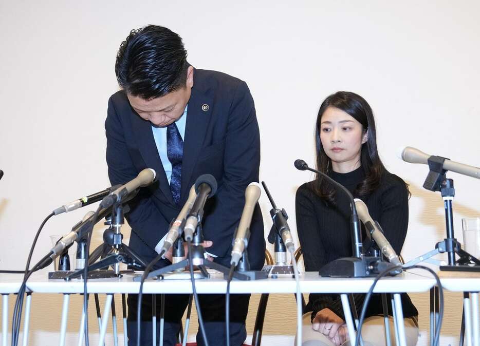 記者会見で頭を下げる大阪府岸和田市の永野耕平市長（左）。右は妻の紗代氏＝24日午後、大阪府岸和田市（沢野貴信撮影）