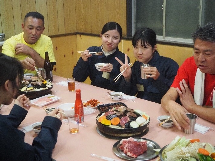 地元の人たちと名物のジンギスカンを食す参加者。