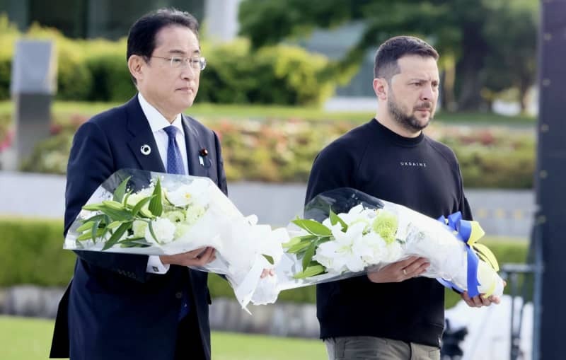 花束を手に原爆慰霊碑への献花に向かう岸田文雄前首相（左）とウクライナのゼレンスキー大統領＝2023年５月、広島市の平和記念公園