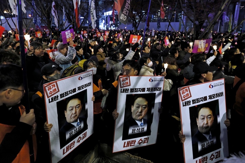 ろうそくを手に韓国の尹錫悦大統領の退陣などを求めて抗議活動する人たち＝5日、ソウル（共同）