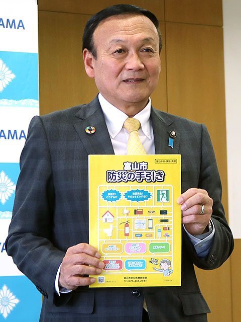 防災の手引きを説明する藤井市長＝富山市役所