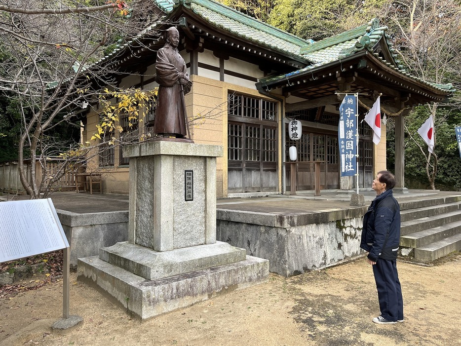 2010年に建てられた福原越後の銅像を眺める参拝者（宇部護国神社で）