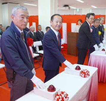 焼却炉の点火ボタンを押す名護市の渡具知武豊市長（左から２人目）と安和区の崎浜秀雄区長（左）＝３日、同市安和