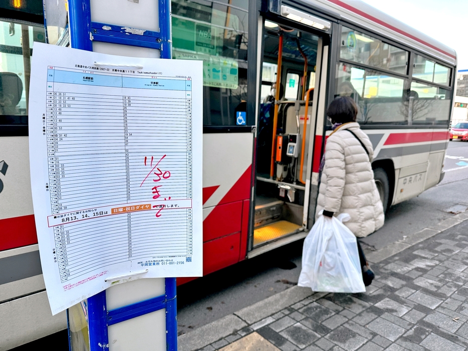 今月から減便されるダイヤが掲示された北海道中央バスの停留所=札幌市豊平区