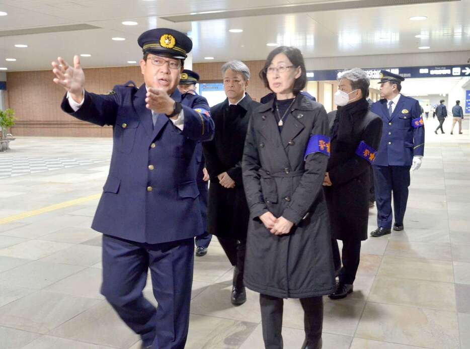 鹿児島西署の川路康隆刑事官の説明を受けながら視察する県公安委員会の石窪奈穂美委員長（前列右）ら＝２５日午後６時５分ごろ、鹿児島市中央町