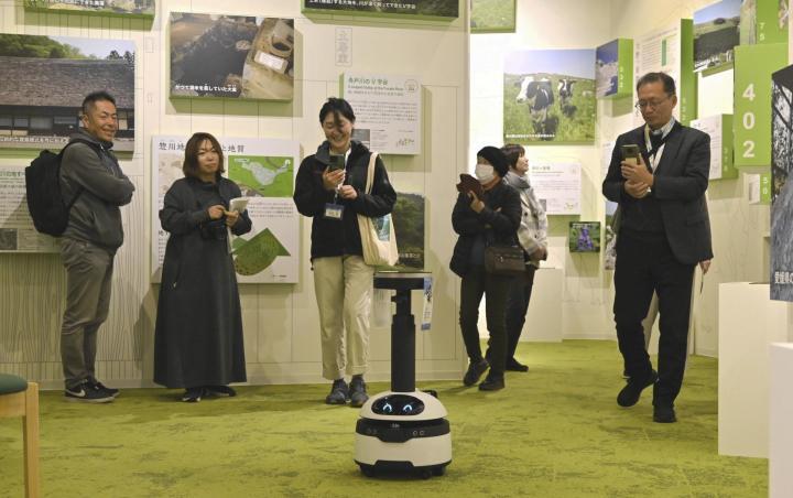 宇和特別支援学校の生徒が遠隔操作するロボット（手前）を通して、西予市内の見どころを学ぶ来館者ら