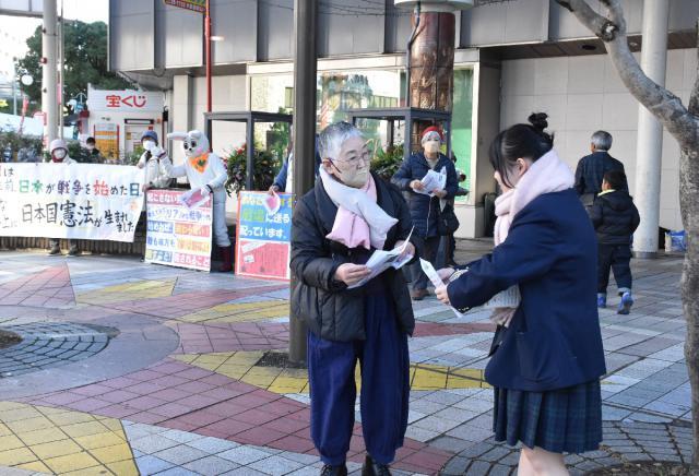 赤紙を模したビラを配り、平和の大切さを訴える県母親大会実行委のメンバー＝８日午後、宮崎市・宮崎山形屋前