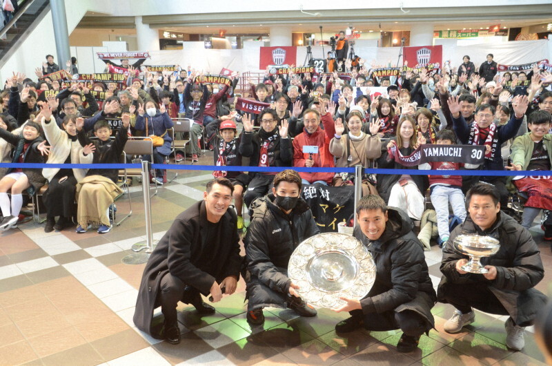 引退試合に先立って開かれた神戸のJ1と天皇杯の優勝報告会でサポーターと記念撮影する槙野智章さん（手前左端）と吉田孝行監督（同右端）ら＝神戸市内で2024年12月14日、生野貴紀撮影