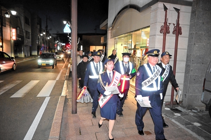 街中を歩いて警戒する牧田さん（左）と署員ら関係者