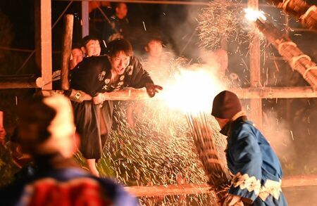 火の粉が激しく舞う中、威勢のいいかけ声を響かせて合戦を演じる男衆＝4日夜、伊万里市二里町の神原八幡宮（撮影・山田宏一郎）